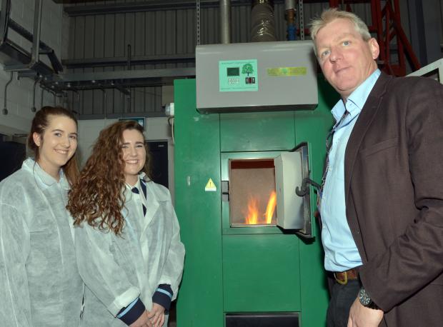 Lydia Poots and Sophie Thompson (Dromore High School) with Chris Johnston (AFBI) at the boiler which provides hot water for the Hillsborough site from burning renewable willow woodchip.